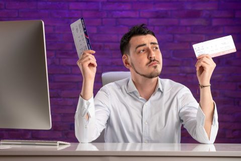 front-view-office-worker-sitting-his-working-place-holding-tickets_optimized