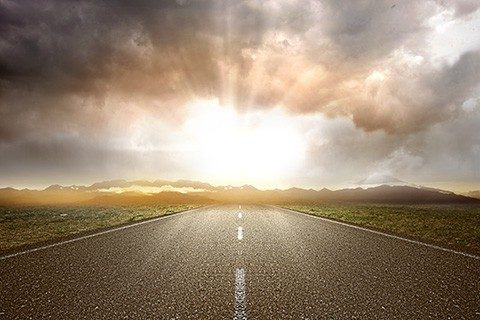 Asphalt road with green grass and mountain view with sunlight background