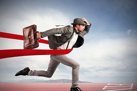 Businessman with bag goes beyond the red ribbon at the arrival of a race